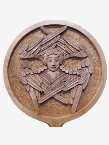 rhipidion sculpté avec une tête qui émerge des ailes